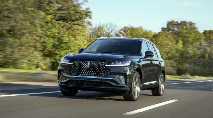 A 2025 Lincoln Black Label Aviator® SUV is being driven down a road lined with trees. | Joe Cooper Lincoln of Edmond in Oklahoma City OK