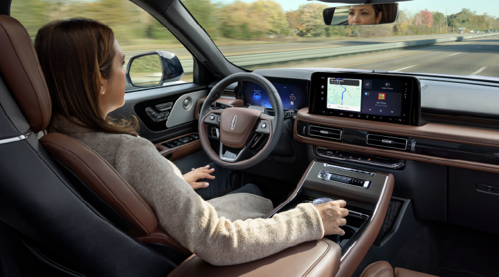 A woman is seen sitting in the driver’s seat of her 2025 Lincoln Aviator® SUV with her hands off the steering wheel. | Joe Cooper Lincoln of Edmond in Oklahoma City OK