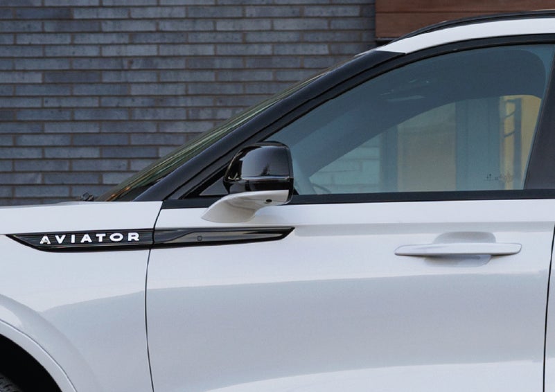 The driver’s side door and fender badging of a white 2026 Lincoln Aviator® SUV are showcased. | Joe Cooper Lincoln of Edmond in Oklahoma City OK