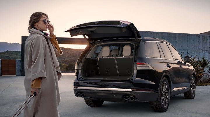 A woman approaches a 2026 Lincoln Aviator® SUV with its rear liftgate open. | Joe Cooper Lincoln of Edmond in Oklahoma City OK