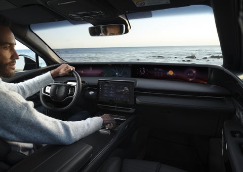 A driver of a parked 2026 Lincoln Nautilus® SUV takes a relaxing moment at a seaside overlook while inside his Nautilus. | Joe Cooper Lincoln of Edmond in Oklahoma City OK